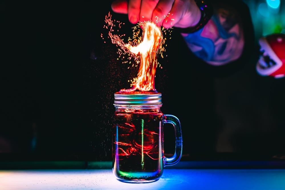 En bartender som blandar en brinnande cocktail.